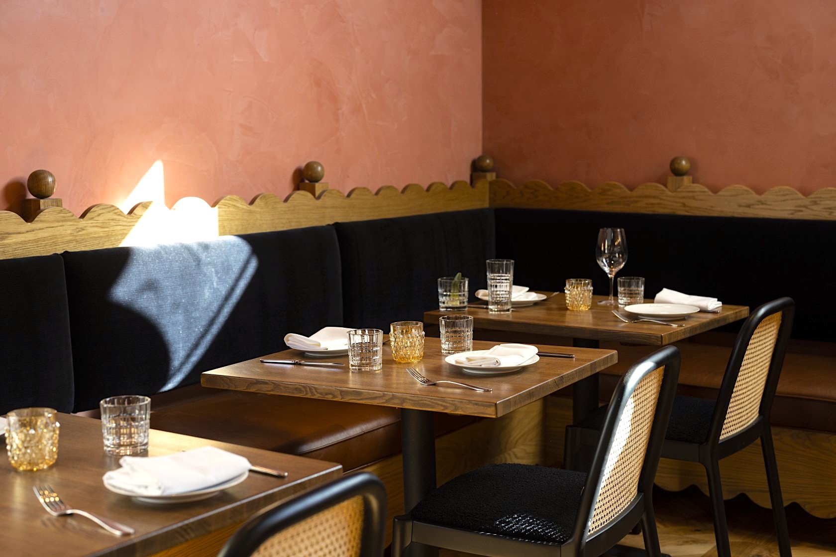 A cozy dining area with booth seating and tables set for guests.