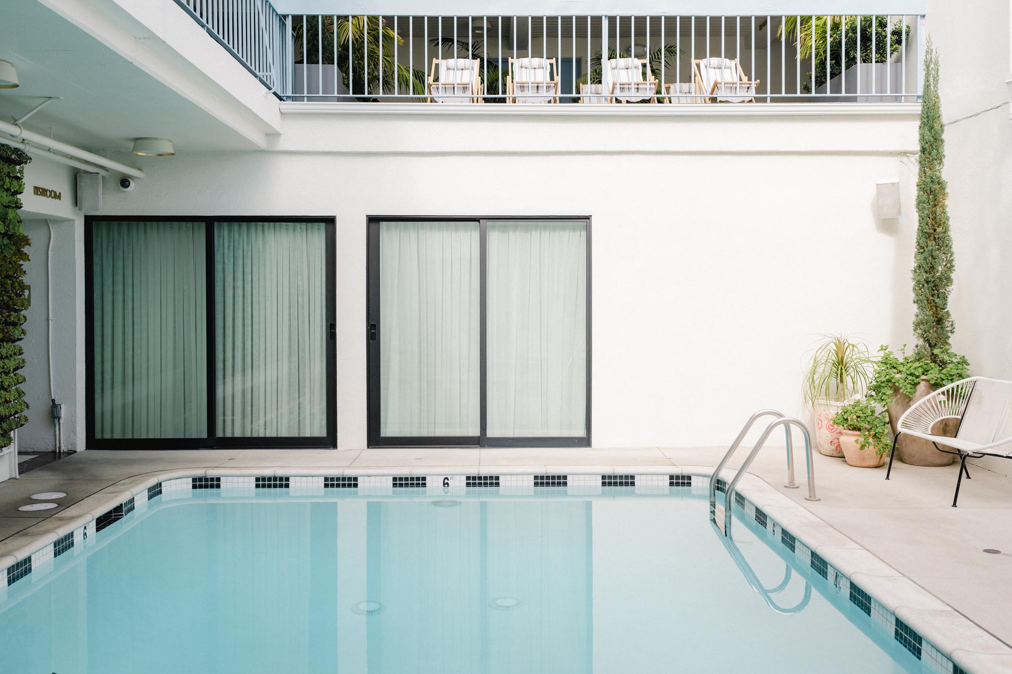 A swimming pool with a balcony and chairs above it