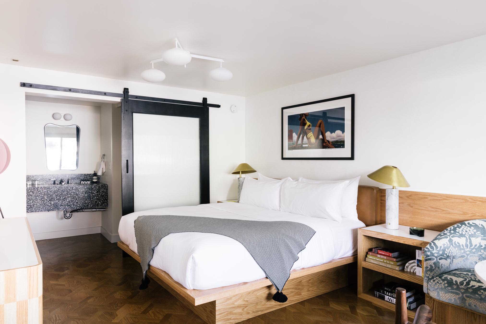 A hotel room with a bed, nightstand, and bathroom door